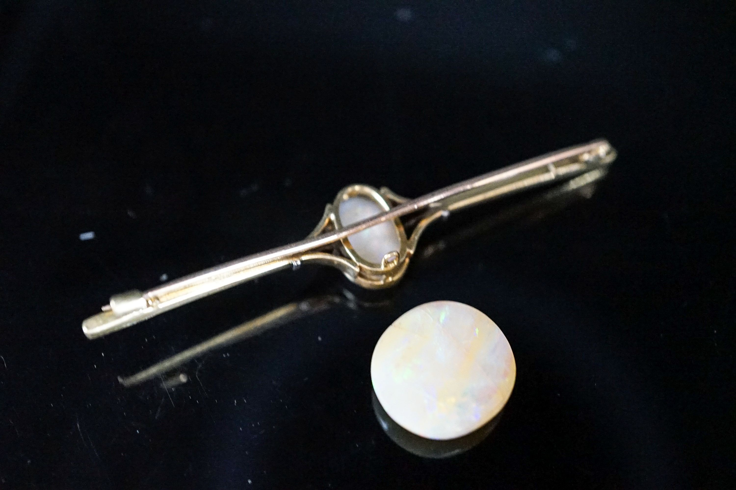 A yellow metal and white opal set bar brooch, 63mm, gross 4.9 grams and a loose white opal.